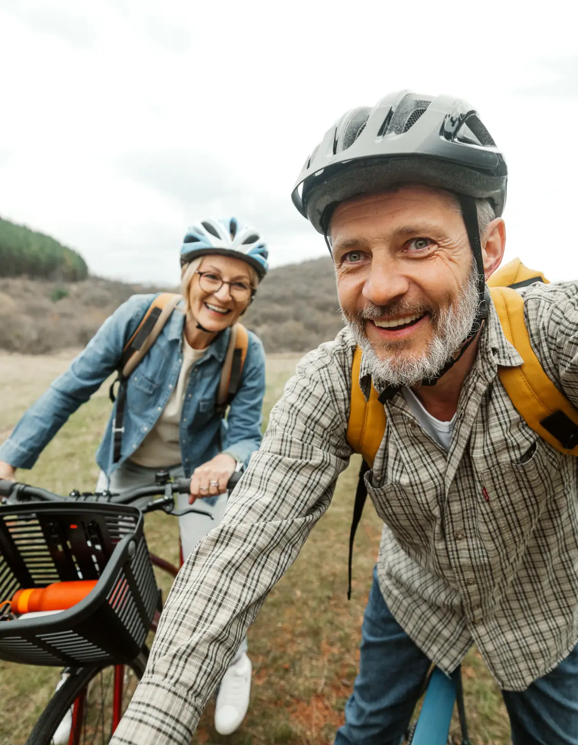 A man and a women biking through a field.