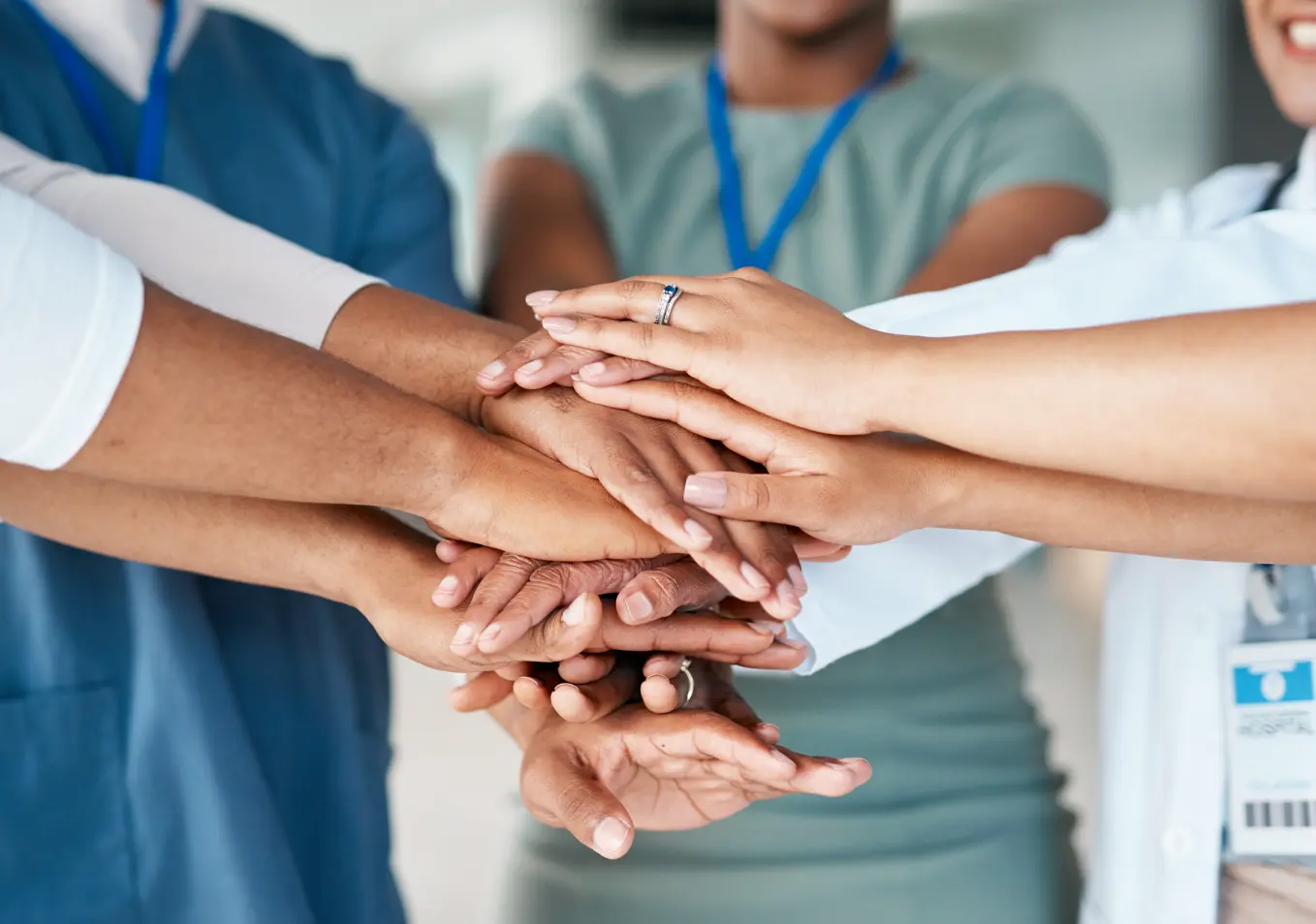Close up of various people's hands stacked together in a huddle