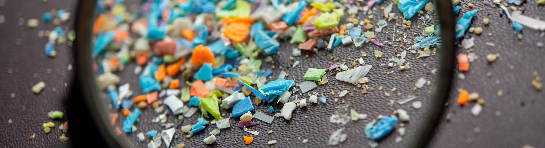 Broken pieces of plastic under a magnifying glass.